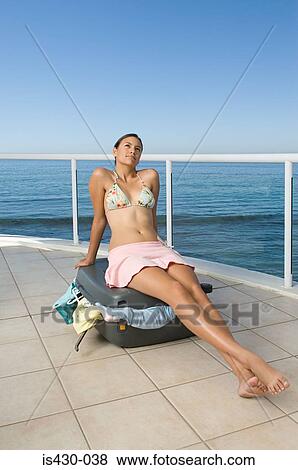 Woman sitting on suitcase View Large Photo Image Stock Photo - Woman sitting on suitcase. Fotosearch