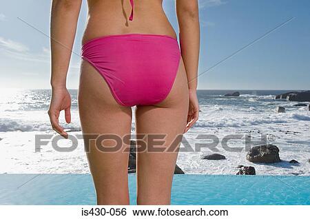 Woman standing by infinity pool View Large Photo Image Stock Photograph - Woman standing by infinity pool. Fotosearch