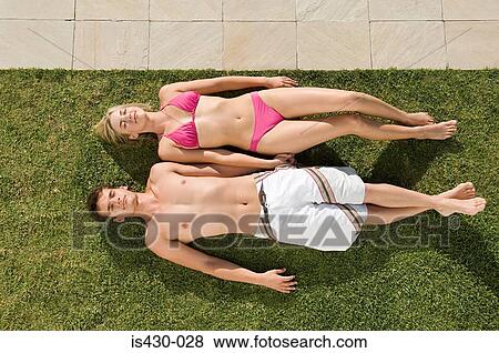 Young couple sunbathing View Large Photo Image Stock Photo - Young couple sunbathing. Fotosearch