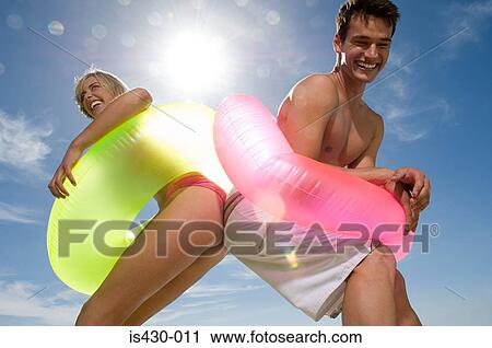 Stock Image - Young couple touching buttocks. Fotosearch