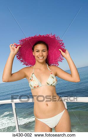 Young woman in bikini and sunhat View Large Photo Image Stock Image - Young woman in bikini and sunhat. Fotosearch