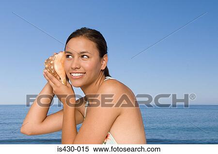 Young woman with conch shell View Large Photo Image Stock Photography - Young woman with conch shell. Fotosearch