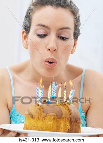 Stock Image - Woman blowing out candles. Fotosearch