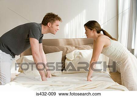 Couple facing each other across bed View Large Photo Image Stock Photo - Couple facing each other across bed. Fotosearch