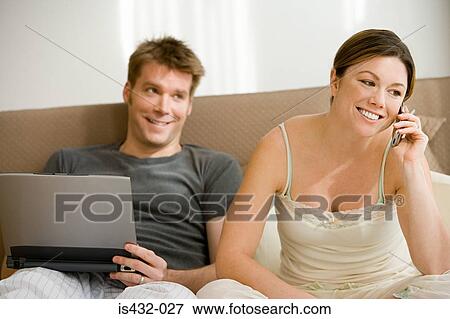 Couple with cellphone and laptop View Large Photo Image Stock Photo - Couple with cellphone and laptop. Fotosearch