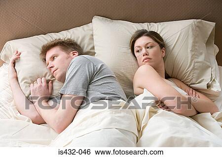 Stock Photograph - Hostile couple in bed. Fotosearch