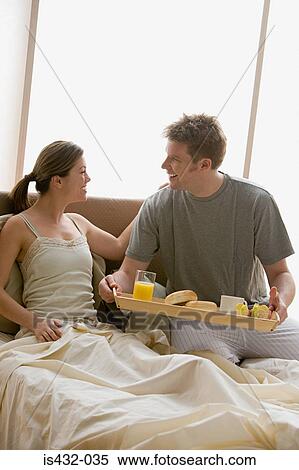 Stock Photography - Man bringing woman breakfast in bed. Fotosearch
