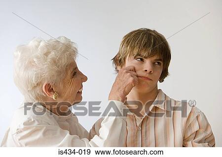 Woman grabbing grandson's cheek View Large Photo Image Stock Photo - Woman grabbing grandson's cheek. Fotosearch