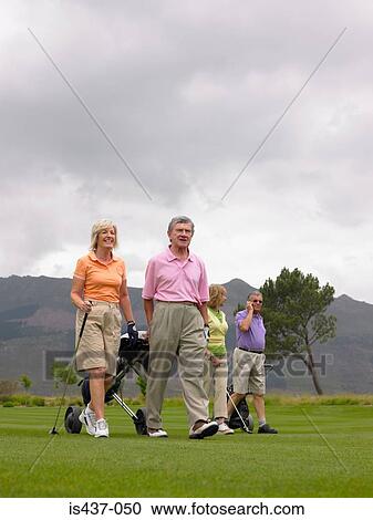Golfers walking on course View Large Photo Image Stock Image - Golfers walking on course. Fotosearch