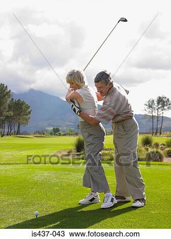 Man giving woman a golf lesson View Large Photo Image Stock Image - Man giving woman a golf lesson. Fotosearch