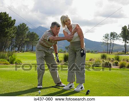 Man giving woman a golf lesson View Large Photo Image Stock Image - Man giving woman a golf lesson. Fotosearch