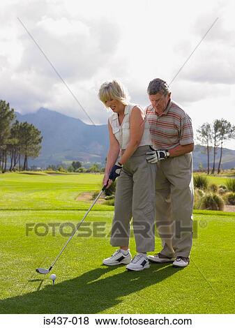 Man giving woman a golf lesson View Large Photo Image Stock Photo - Man giving woman a golf lesson. Fotosearch