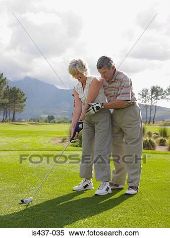 Man giving woman a golf lesson View Large Photo Image Stock Photography - Man giving woman a golf lesson. Fotosearch