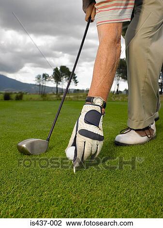 Man placing golf ball on tee View Large Photo Image Stock Image - Man placing golf ball on tee. Fotosearch