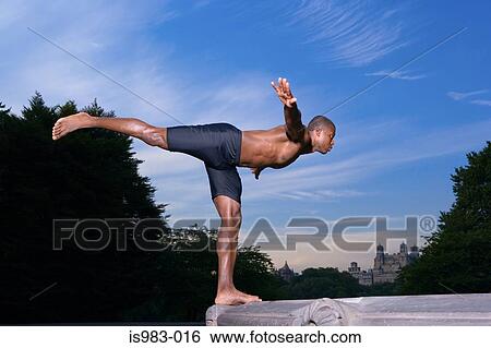 Stock Photograph - Athlete balancing on a fountain. Fotosearch