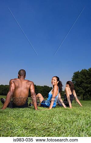 Joggers sitting on the grass View Large Photo Image Stock Photography - Joggers sitting on the grass. Fotosearch