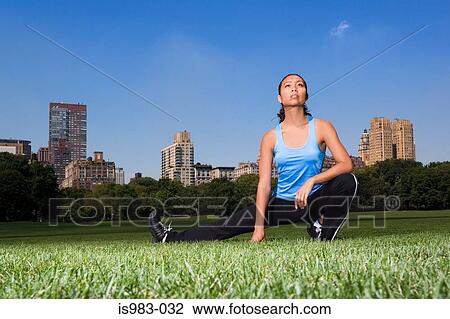 Stock Image - Woman stretching in the park. Fotosearch