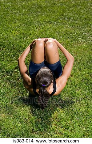 Picture - Woman stretching on the grass. Fotosearch