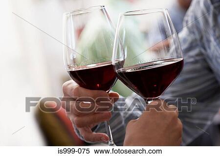 Couple toasting with red wine View Large Photo Image Stock Photography - Couple toasting with red wine. Fotosearch