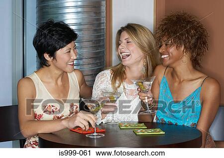 Stock Image - Female friends having cocktails. Fotosearch