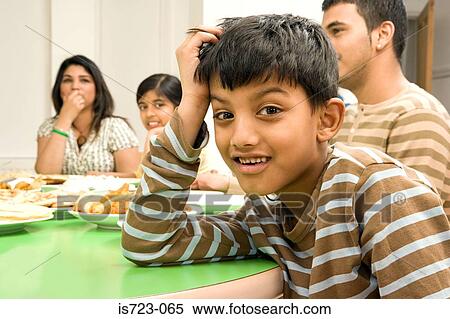 Boy with family at dining table View Large Photo Image Stock Photography - Boy with family at dining table. Fotosearch