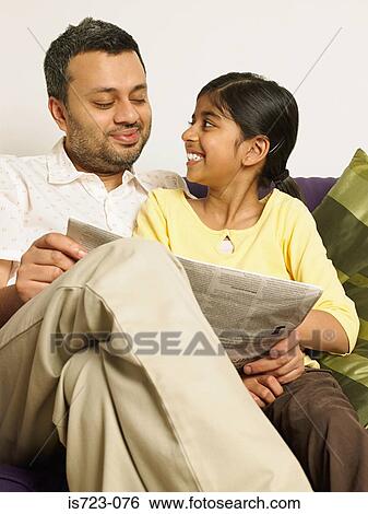 Father and daughter reading a newspaper View Large Photo Image Stock Photograph - Father and daughter reading a newspaper. Fotosearch