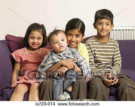 Four children sitting on sofa View Large Photo Image Picture - Four children sitting on sofa. Fotosearch