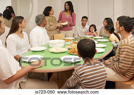 Stock Image - Large family at dining table. Fotosearch