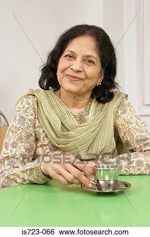 Stock Photograph - Senior woman sitting at table. Fotosearch