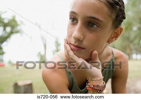 Bored looking girl in a field View Large Photo Image Stock Photograph - Bored looking girl in a field. Fotosearch