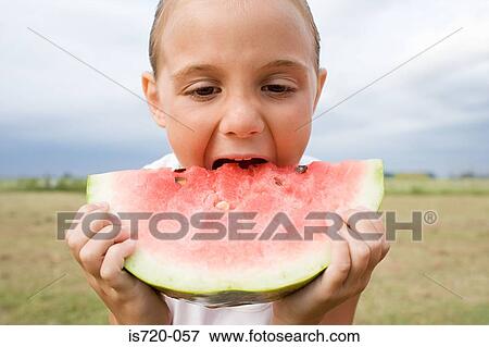 Girl eating a large slice of watermelon View Large Photo Image Stock Photo - Girl eating a large slice of watermelon. Fotosearch