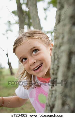 Girl hiding behind tree View Large Photo Image Stock Image - Girl hiding behind tree. Fotosearch