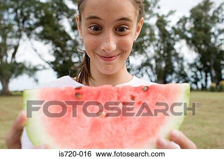 Girl holding a large slice of watermelon View Large Photo Image Stock Photograph - Girl holding a large slice of watermelon. Fotosearch