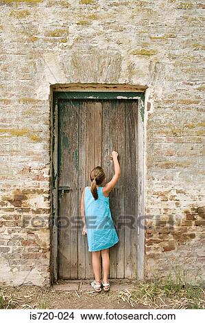 Girl knocking on a wooden door View Large Photo Image Picture - Girl knocking on a wooden door. Fotosearch