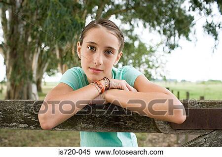 Girl leaning on a wooden fence View Large Photo Image Stock Photography - Girl leaning on a wooden fence. Fotosearch