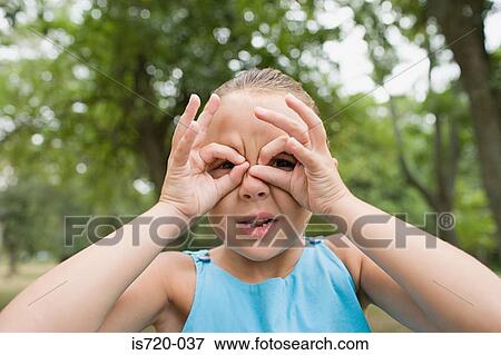 Stock Photo - Girl looking through her fingers. Fotosearch