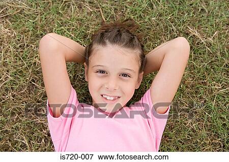 Girl lying on grass View Large Photo Image Stock Photo - Girl lying on grass. Fotosearch