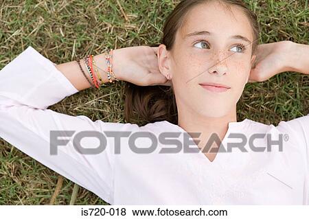 Girl lying on grass View Large Photo Image Stock Photo - Girl lying on grass. Fotosearch