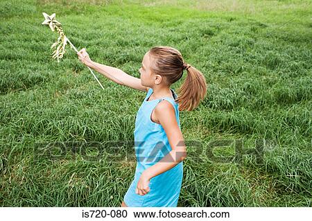 Stock Image - Girl playing in field. Fotosearch