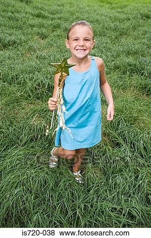 Girl playing in field View Large Photo Image Stock Photo - Girl playing in field. Fotosearch