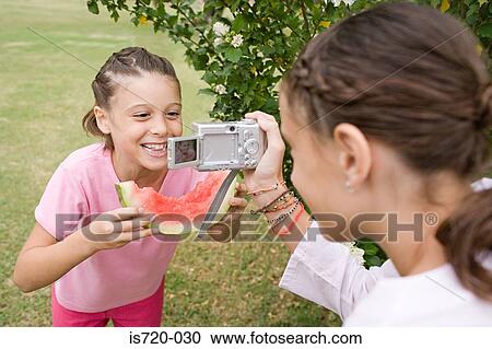Stock Image - Girl posing for a photograph. Fotosearch