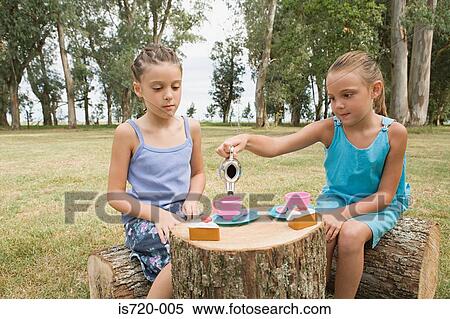 Girls having a tea party in field View Large Photo Image Stock Photography - Girls having a tea party in field. Fotosearch