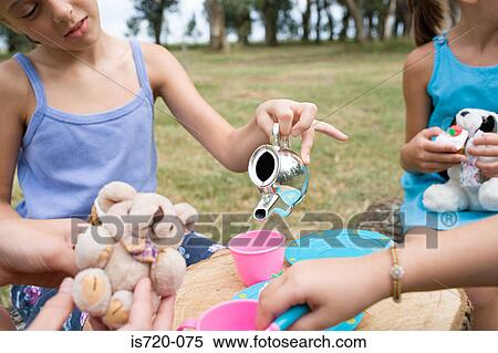Girls having a tea party in field View Large Photo Image Stock Photography - Girls having a tea party in field. Fotosearch
