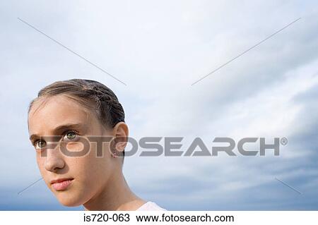 Serious looking girl and cloudy sky View Large Photo Image Stock Image - Serious looking girl and cloudy sky. Fotosearch