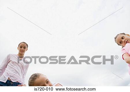 Three girls and a cloudy sky View Large Photo Image Stock Image - Three girls and a cloudy sky. Fotosearch