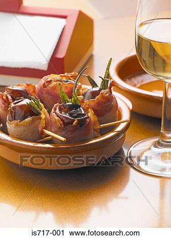 Stock Image - Bacon wrapped dates. Fotosearch