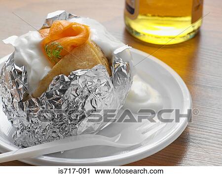 Stock Image - Baked potato with salmon and cream. Fotosearch