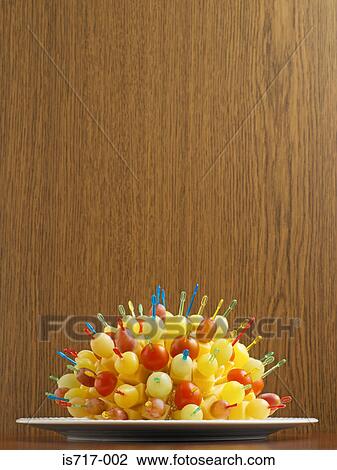 Stock Image - Cheese on cocktail sticks with grapes and tomatoes. Fotosearch