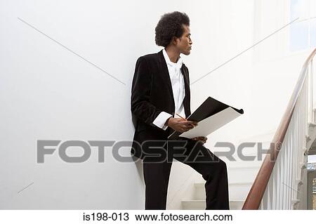 Stock Image - Man on stairs with sketch book. Fotosearch
