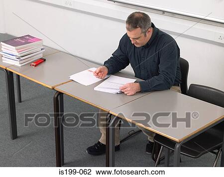 Teacher marking paperwork View Large Photo Image Stock Image - Teacher marking paperwork. Fotosearch
